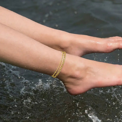 2Pcs Stainless Steel Anklet Set for Women - Silver Jewelry worn on a foot near the water.